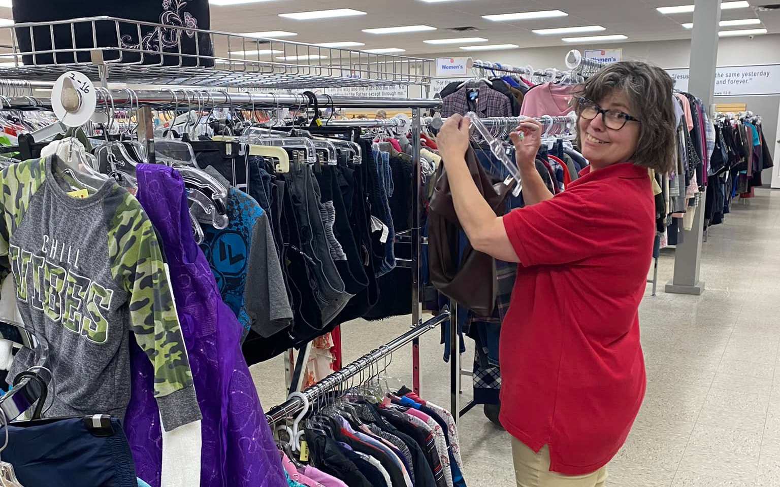 A thrift store employee sorting on the rack