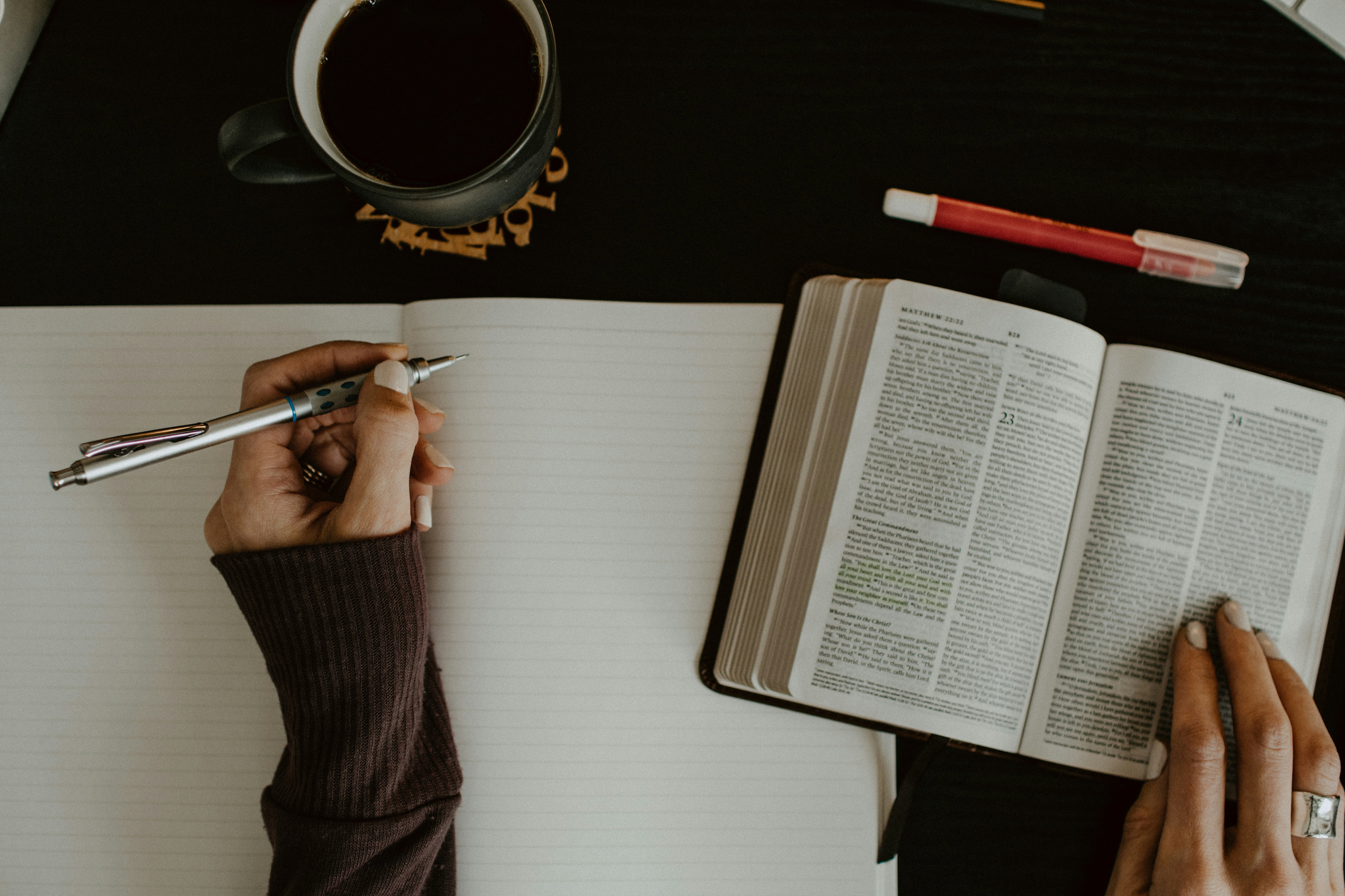 Overhead view of a person reading a Bible and taking notes